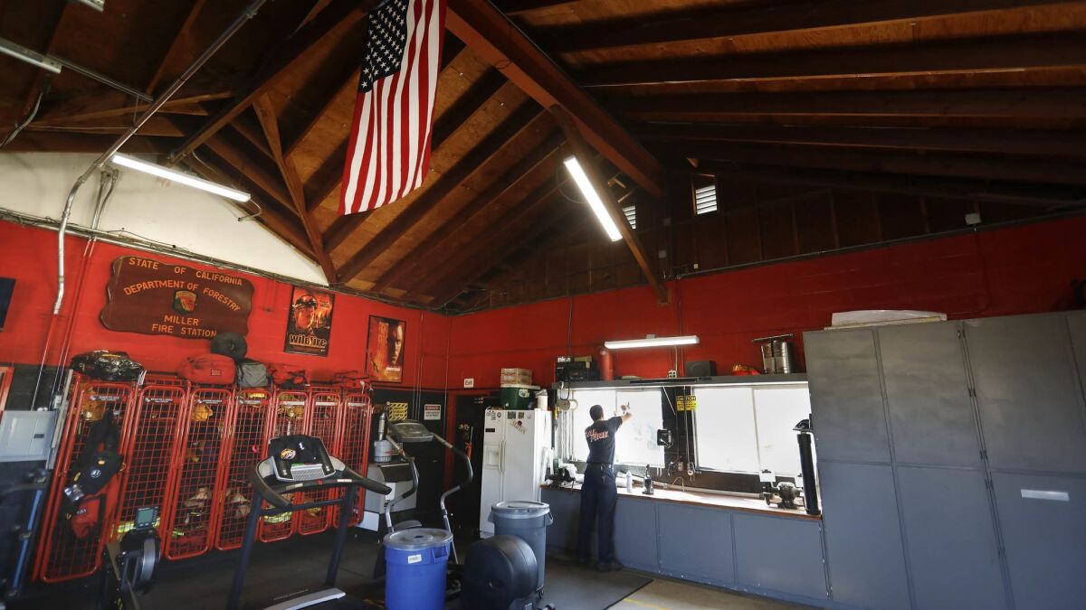 Cal Fire firefighter Anthony Lopez cleans a window in Cal Fire San Diego Miller Fire Station 15 on West Lilac Road in Valley Center as part of the chores all firefighters do while waiting for calls.