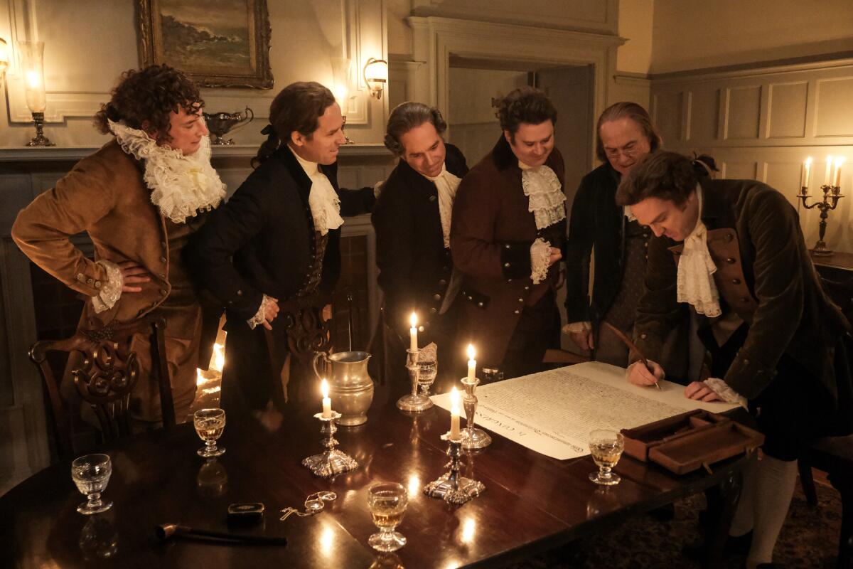 Six men lasting astir a candlelit array looking astatine a ample papers that is being signed.