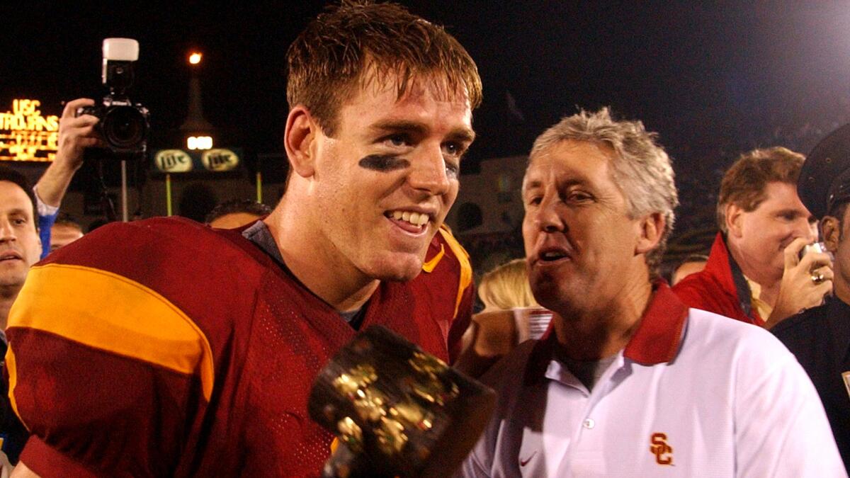 On Nov. 30, 2002, USC quarterback Carson Palmer is congratulated by coach Pete Carroll after leading the Trojans to a 44-13 win over Notre Dame. 
