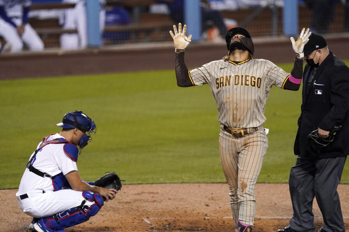 The Padres' Fernando Tatis Jr. looks skyward in celebrating a third-inning homer as Dodgers catcher Austin Barnes looks on.