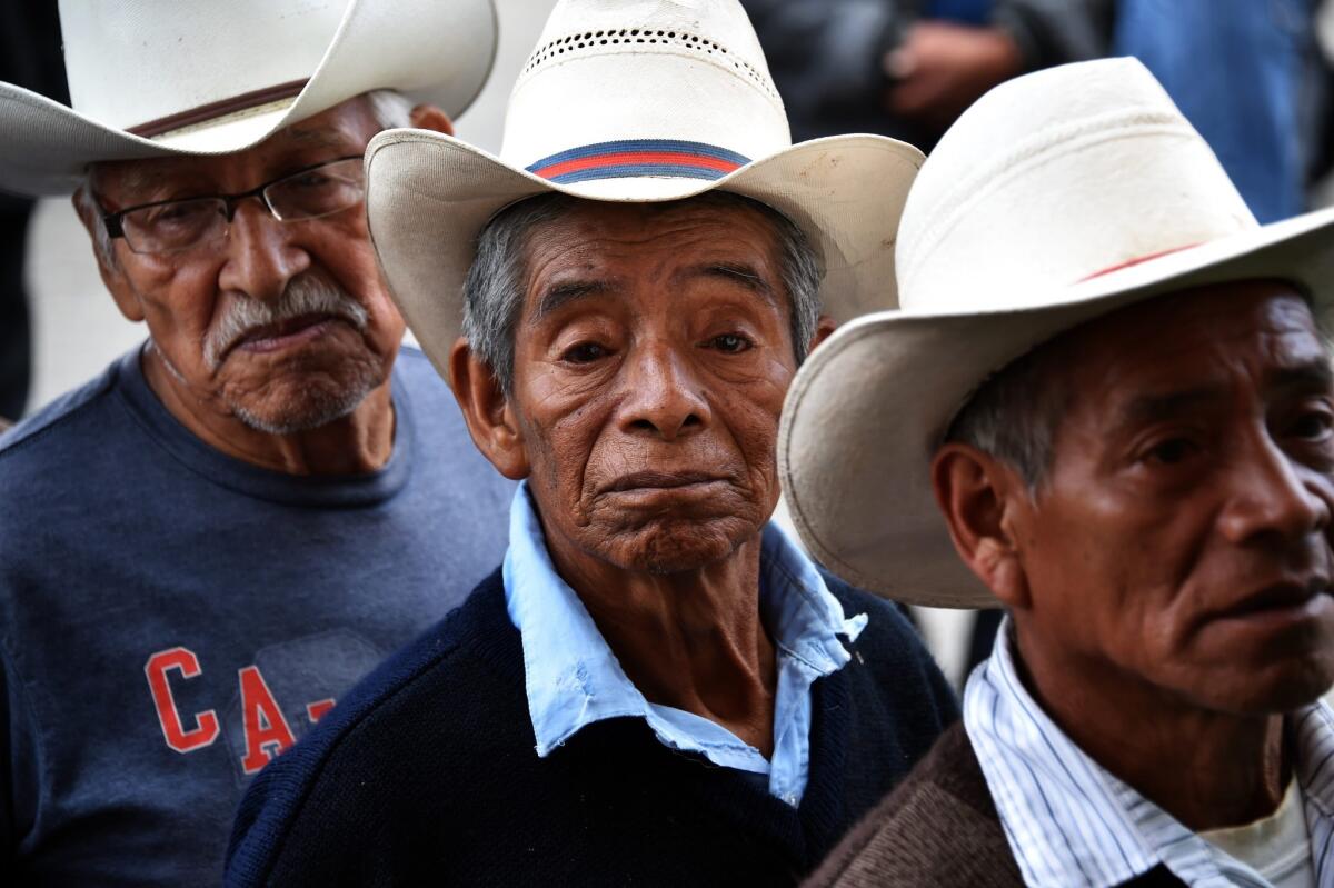 Men line up at a polling station in San Juan Sacatepequez, west of Guatemala City, during Guatemala's presidential election Sunday.