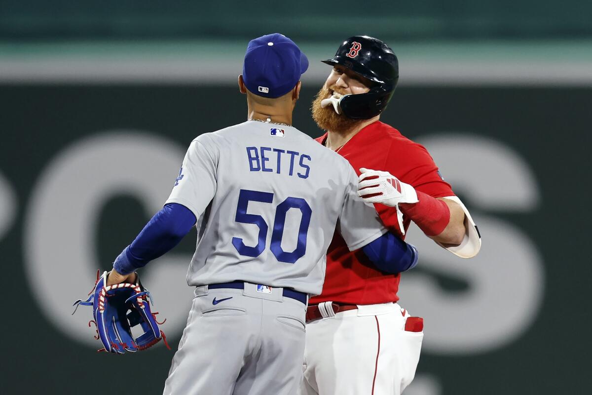Dodgers second baseman Mookie Betts hugs Boston's Justin Turner during the seventh inning Friday.