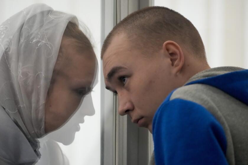Russian Sgt. Vadim Shishimarin listens to his translator during a court hearing in Kyiv, Ukraine, Monday, May 23, 2022. The 21 year old soldier facing the first war crimes trial since the start of the war in Ukraine plead guilty on May 18 to killing an unarmed civilian. (AP Photo/Natacha Pisarenko)