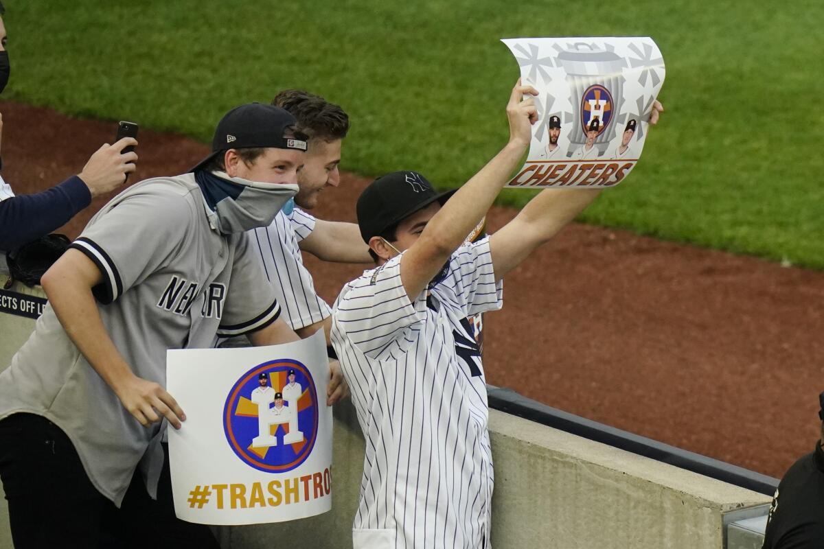 New York Yankees fans hold signs before the start of a game.