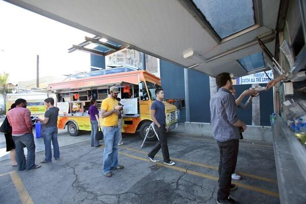 People order and pick up food from the food trucks at the Brig parking lot in Venice.