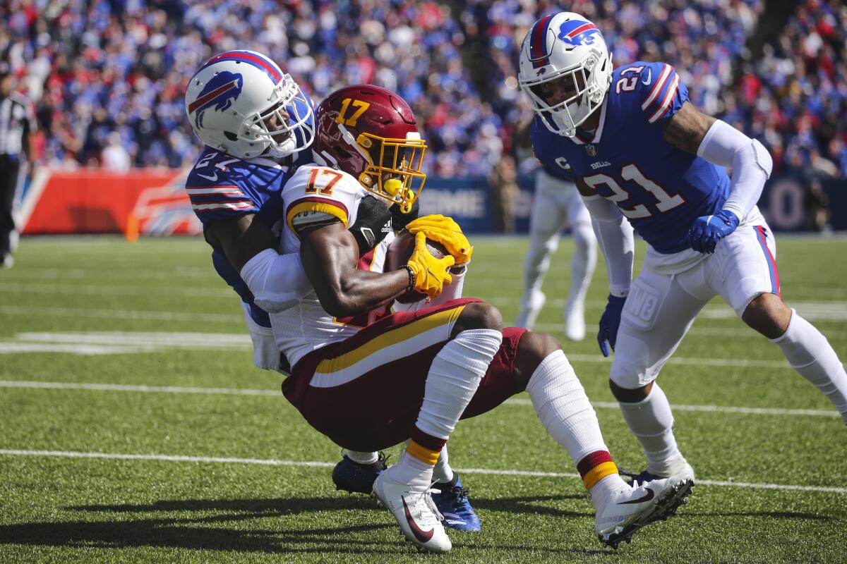 Buffalo Bills' Tre'Davious White (27) tackles Washington Football Team's Terry McLaurin (17) as Bills' Jordan Poyer (21) watches during the first half of an NFL football game Sunday, Sept. 26, 2021, in Orchard Park, N.Y. (AP Photo/Jeffrey T. Barnes)