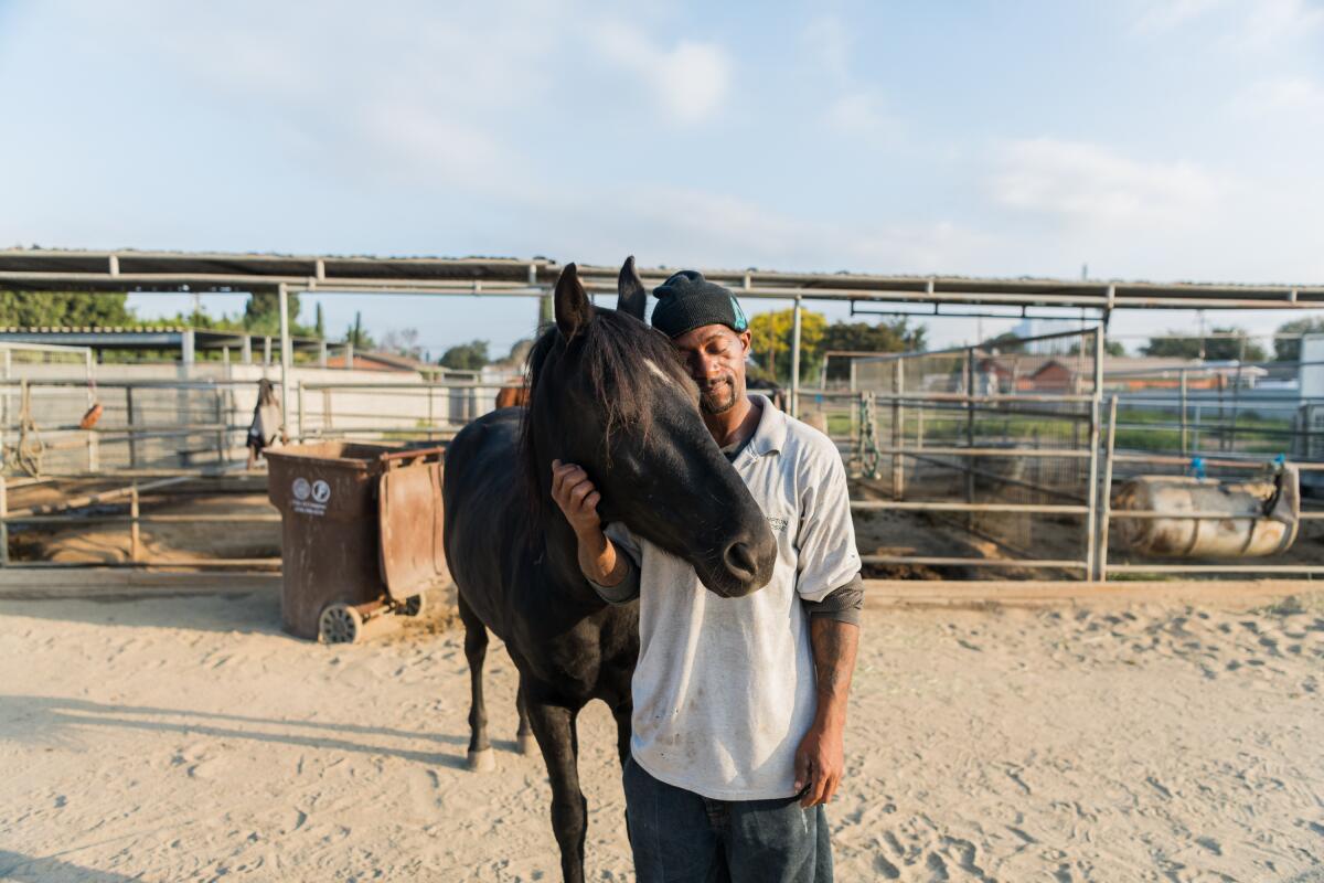 Anthony Harris shares a moment with his horse, Dakota, at Compton's Richland Farms ranch.