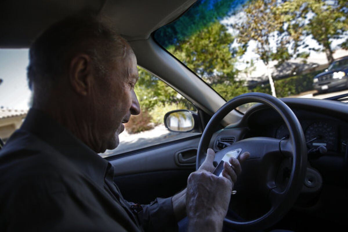 Souliotes programs his cellphone for directions to a restaurant in Escondido. He said of the female voice commands from his phone, "I love the lady who helps me find my way."
