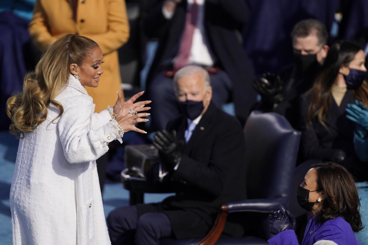 Jennifer Lopez turns to Vice President Kamala Harris after her performance at the inauguration as President Biden looks on.