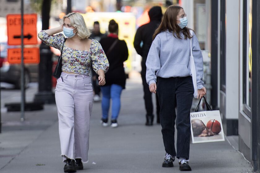 Unas mujeres con cubrebocas para protegerse del coronavirus caminan por una calle de Montreal, Canadá, el 21 de septiembre de 2020. (Graham Hughes/The Canadian Press via AP)