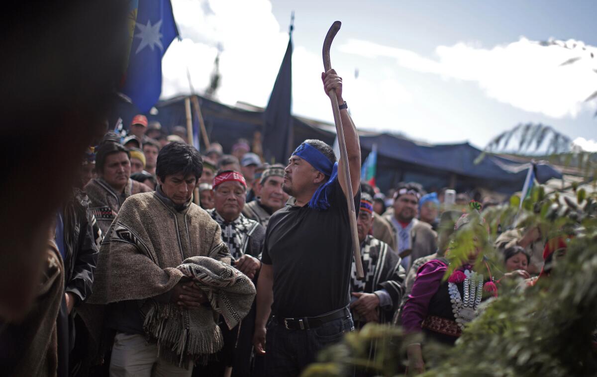 ARCHIVO - El líder mapuche Héctor Llaitul sostiene su bastón junto al ataúd 