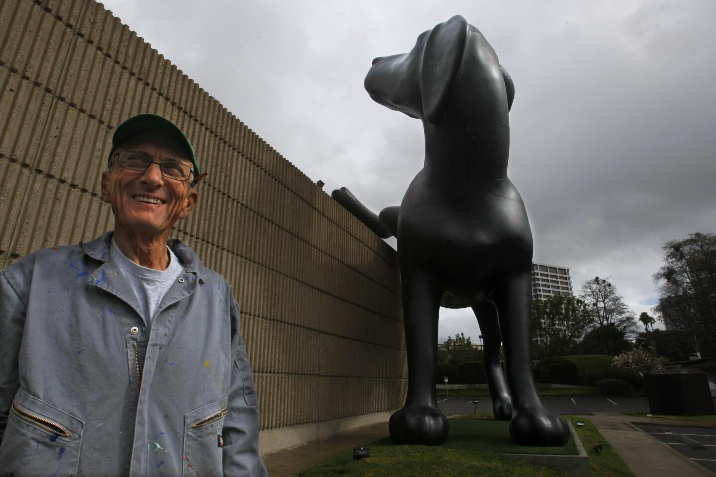 Artist Richard Jackson outside the Orange County Museum of Art in Newport Beach with his sculpture "Bad Dog," 2013, which is designed to spray yellow paint on the museum's walls. Opening Feb. 17 at the museum is a retrospective of the Sierra Madre-based sculptor-painter.