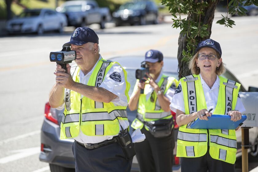 NORTHRIDGE, CA-JULY 24, 2019: left to right-Nishan Darakdjian, 73, and Karla Hanley, 68, use speed guns to catch motorists driving past the speed limit on Reseda Blvd. in Northridge as Amy Schneider, 63, writes down the speed they were going on July 25, 2019. They are volunteers with the Devonshire Community Police Station in Northridge. (Mel Melcon/Los Angeles Times)