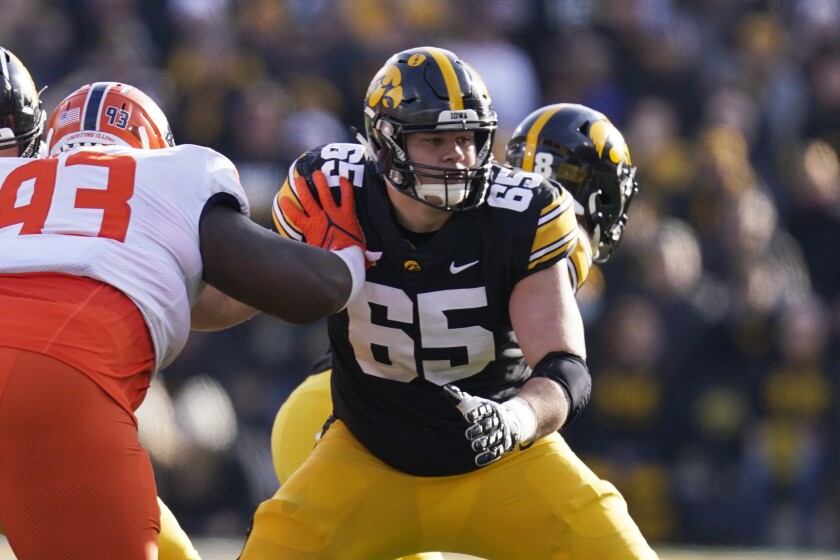 FILE - Iowa offensive lineman Tyler Linderbaum (65) looks to make a block during the first half of an NCAA college football game against Illinois, Nov. 20, 2021, in Iowa City, Iowa. Iowa center Tyler Linderbaum announced Friday, Jan. 14, 2022, he'll skip his senior season and enter the NFL draft. (AP Photo/Charlie Neibergall, File)