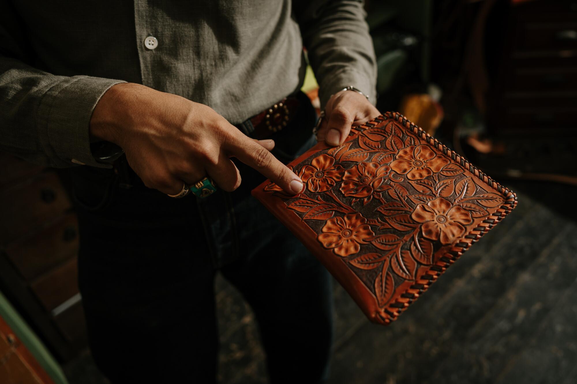 Los Angeles, CA - July 28: Guillermo Cuevas, owner of Dunrite Leatherworks, shows off some of his work