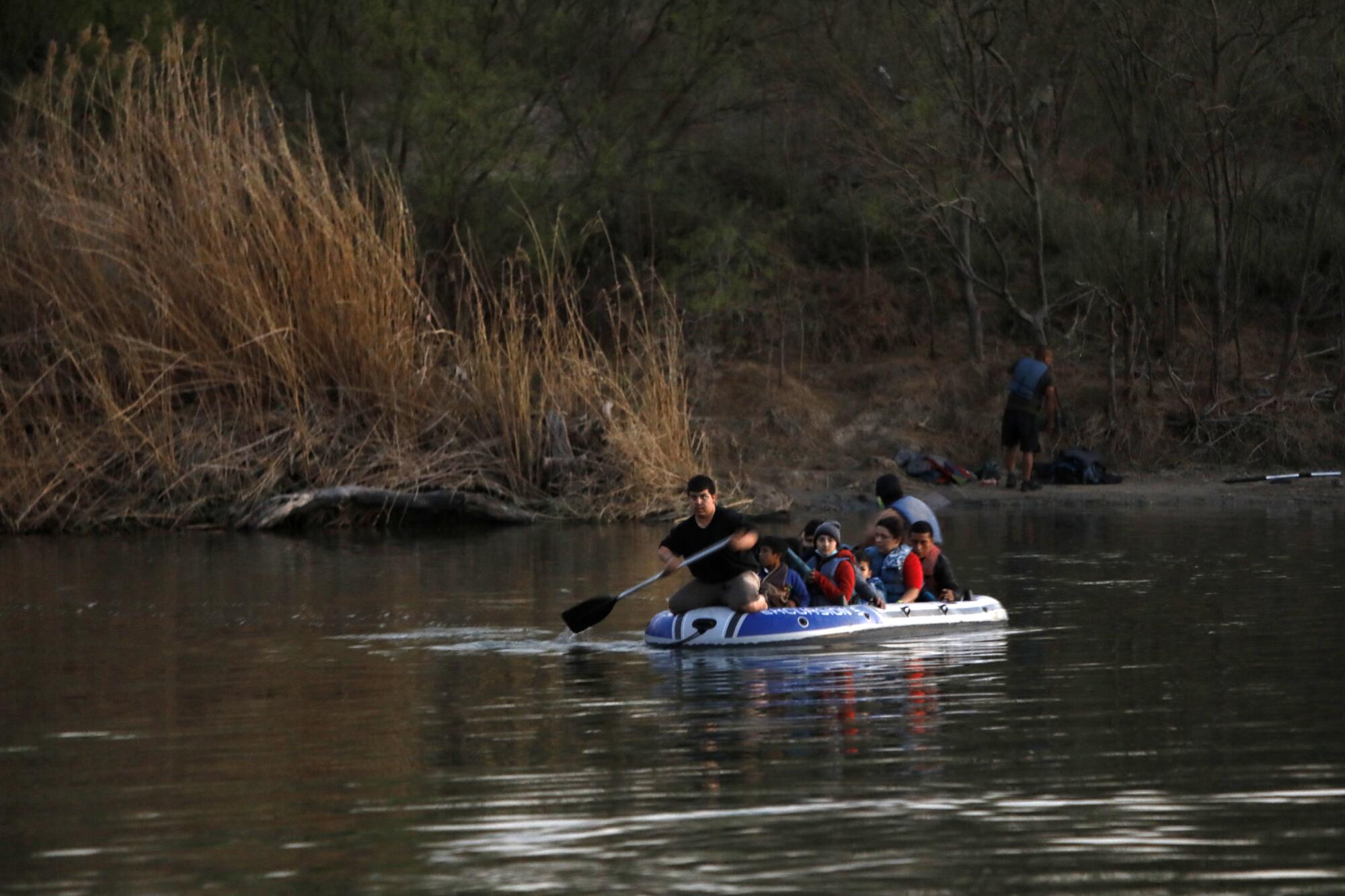 Asylum seekers are transported across the Rio Grande by smugglers on a raft 