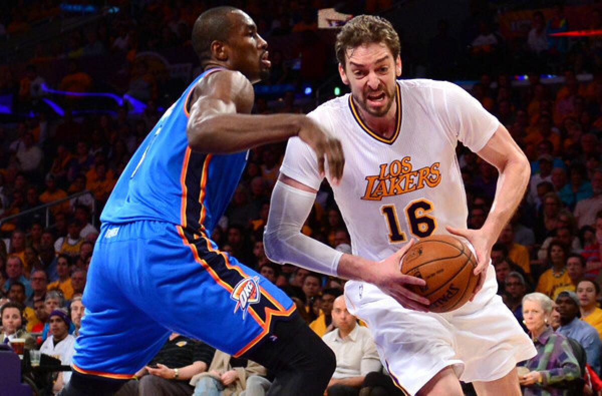 Lakers power forward Pau Gasol (16) drives to the basket against Thunder power forward Serge Ibaka during a 114-110 victory on Sunday at Staples Center.