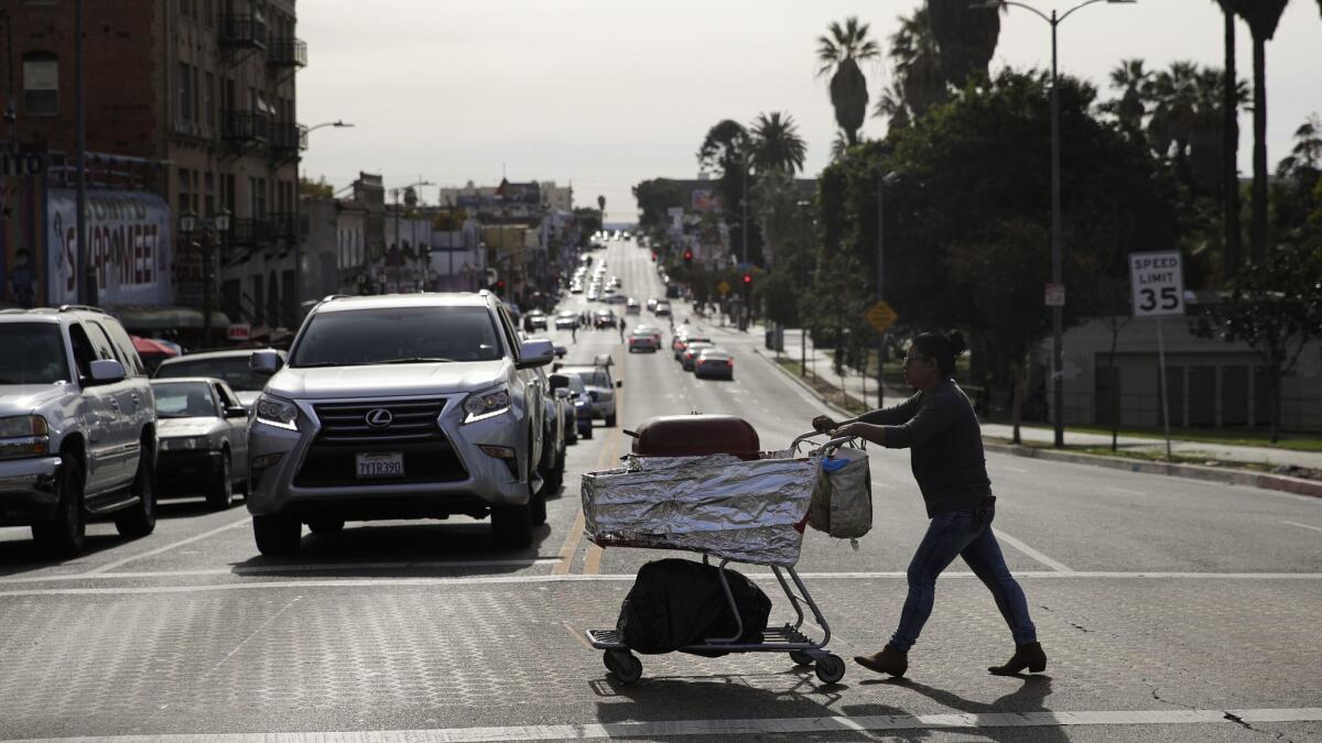 A food vendor pushes her cart in Los Angeles in 2018. The Huntington Beach City Council on Tuesday will consider creating a permit process to allow sidewalk vendors to sell food and other goods, with strict restrictions.