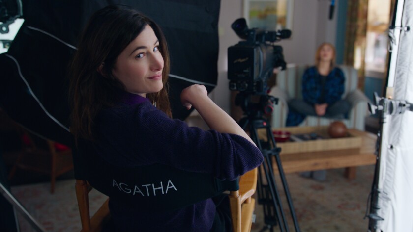Kathryn Hahn looks over the back of a director's chair that says "Agatha"