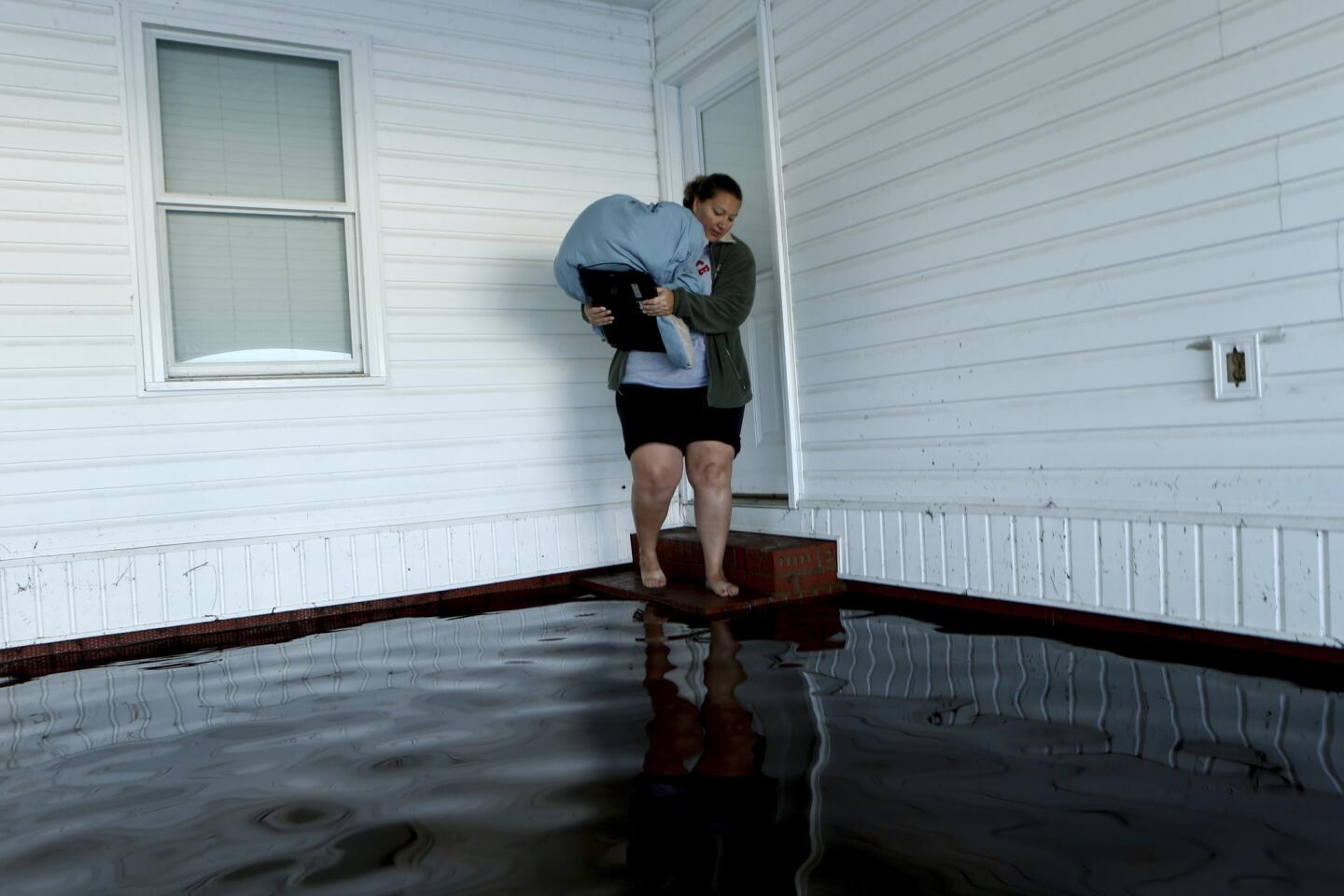 With her home surrounded by floodwaters associated with Hurricane Matthew, Janet Meier prepares to step back into the water in her carport after retrieving a warm blanket and her laptop computer on Oct. 13, 2016 in Lumberton, N.C.