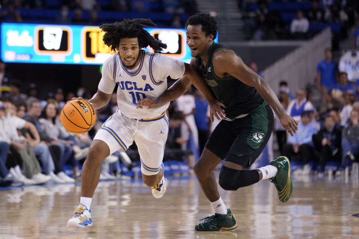 Le garde de l'UCLA Tyger Campbell, à gauche, conduit à côté du garde de l'État de Sacramento Gianni Hunt au cours de la seconde moitié.