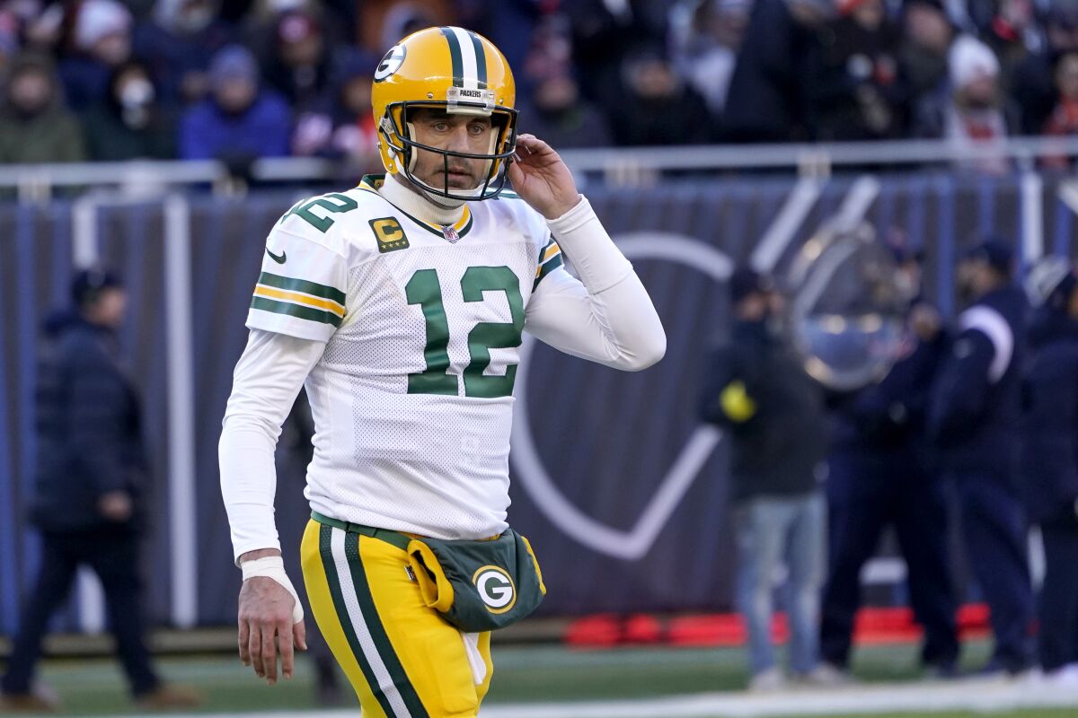 Green Bay Packers quarterback Aaron Rodgers walks off the field with his thumb taped.