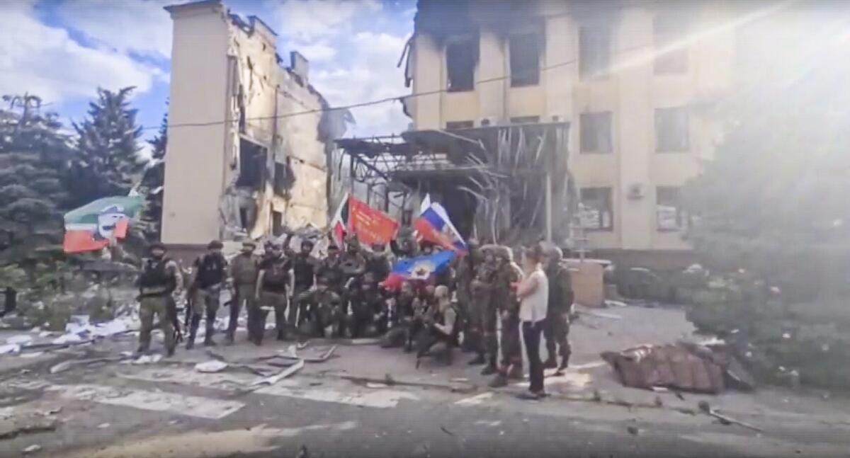 Russian troops in front of a destroyed building in Lysychansk, Ukraine