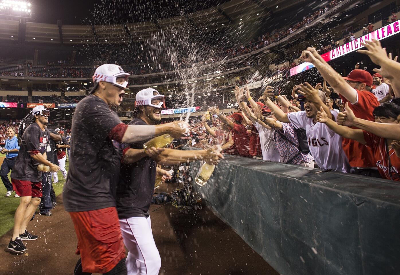 Angels players celebrate with fans after clinching the AL West title on Wednesday night.