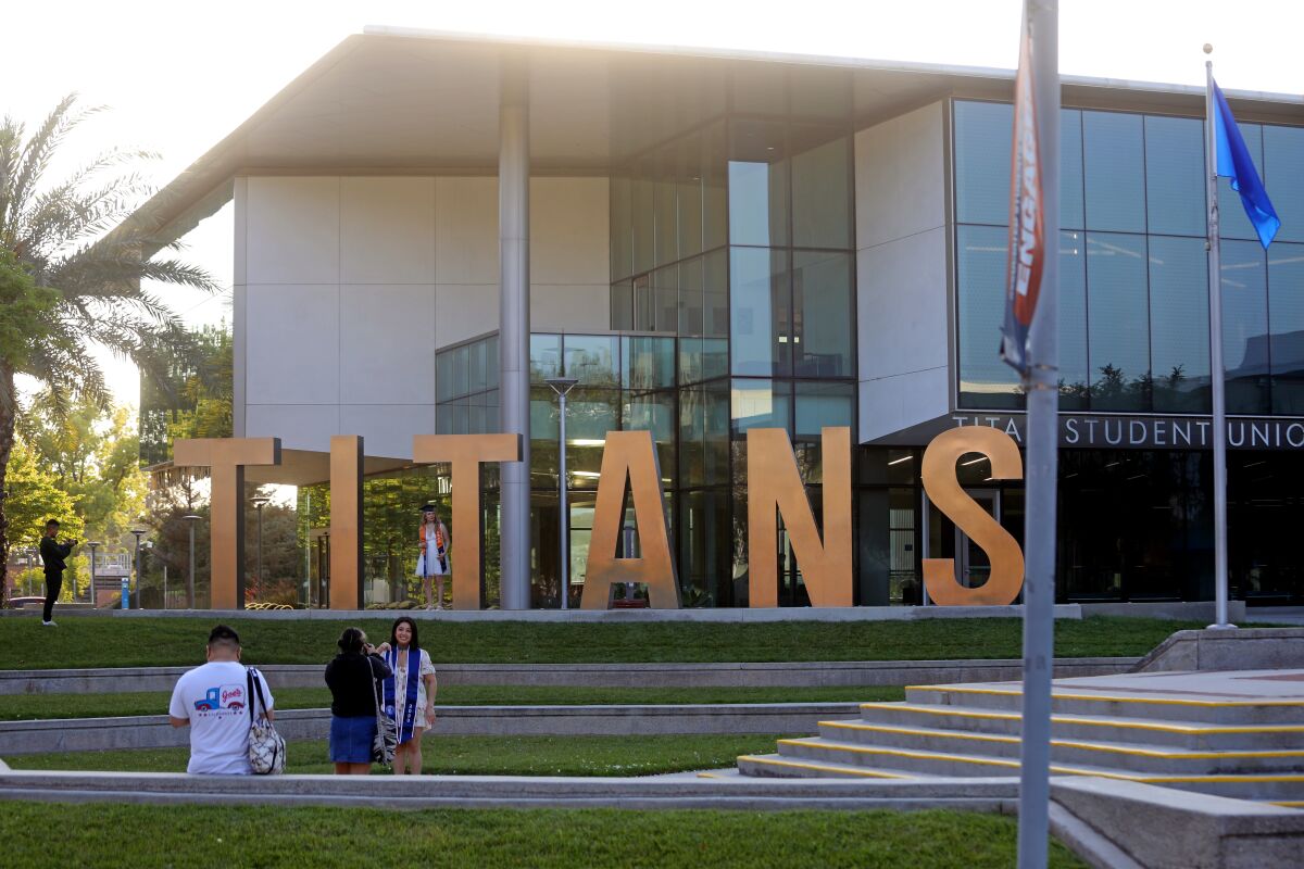 Graduating students pose in front of the Titan Student Union on the campus of California State University, Fullerton