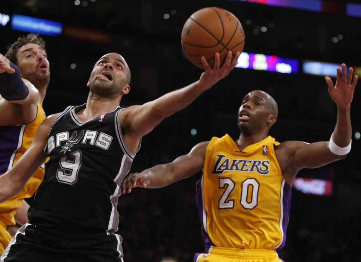 Spurs point guard Tony Parker gets past Lakers power forward Pau Gasol, left, and guard Jodie Meeks for a layup.