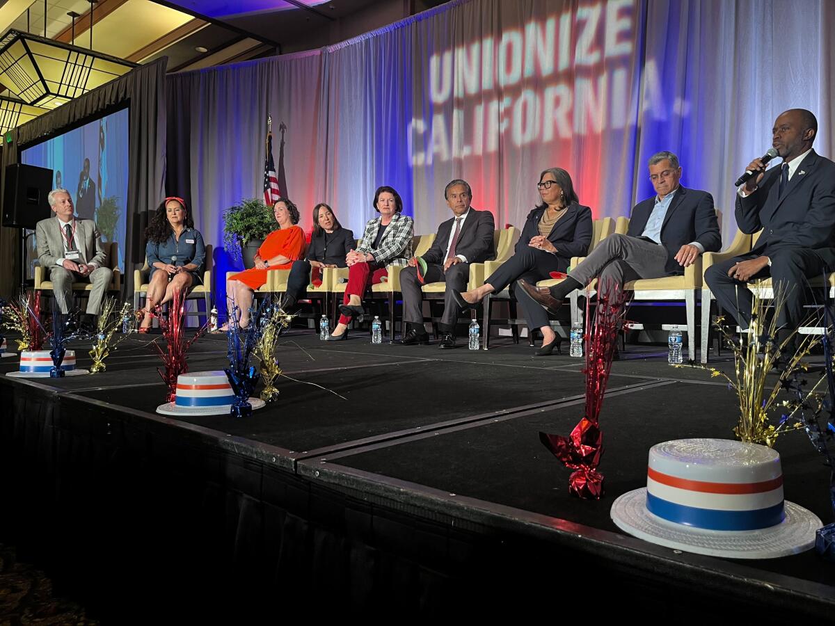 Candidates sit in chairs in front of a curtained backdrop that says "Unionize California."