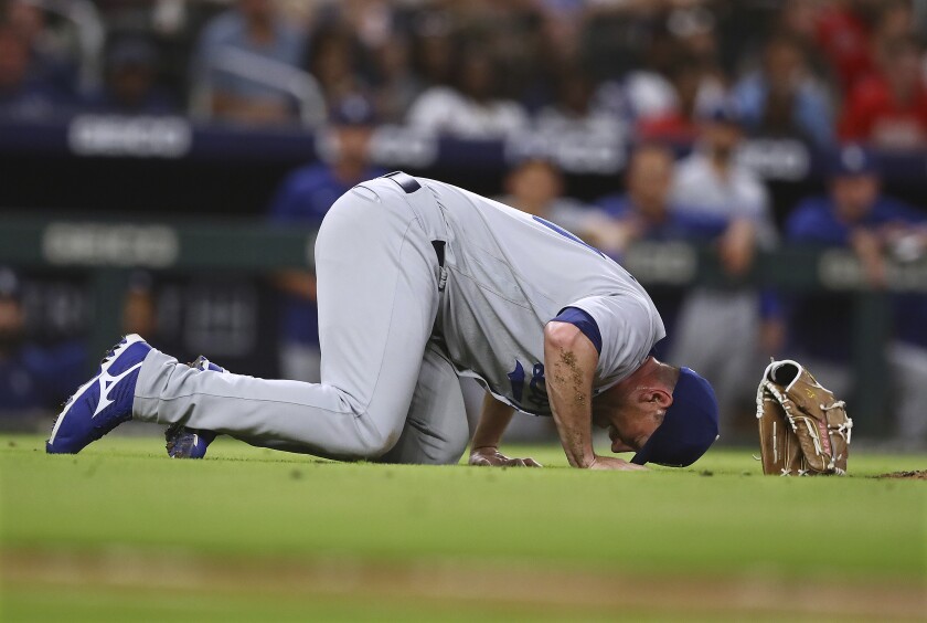 Los Angeles Dodgers reliever Daniel Hudson lies on the field after getting injured trying to field a ground ball during the eighth inning of a baseball game against the Atlanta Braves, Friday, June 24, 2022, in Atlanta. (Curtis Compton/Atlanta Journal-Constitution via AP)