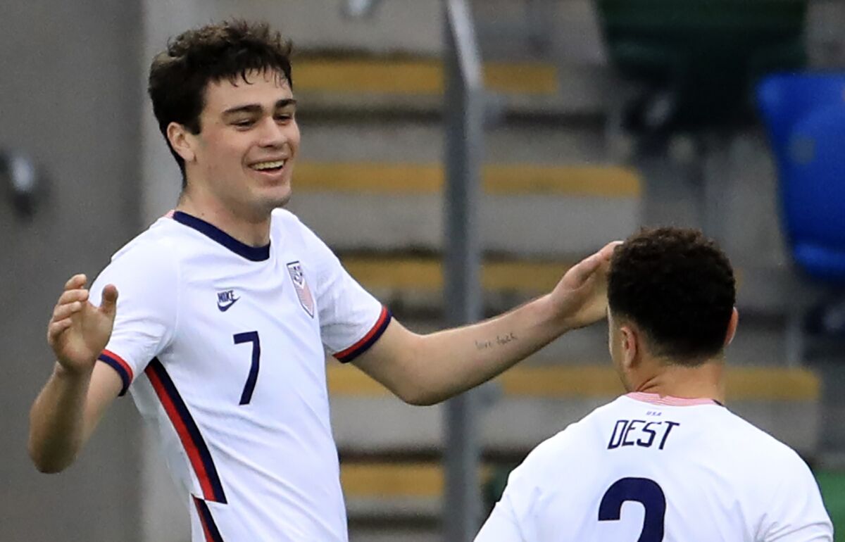 FILE - United States's Gio Reyna, left, celebrates with United States's Sergino Dest after scoring his side's opening goal during an international friendly soccer match between Northern Ireland and United States, at Windsor Park, Belfast, Northern Ireland, Sunday, March 28, 2021. Reyna's could get to play in the Europa League against the team managed by the person he was named after. Reyna, a 19-year-old who debuted for Dortmund last year, was named after Giovanni van Bronckhorst, a teammate of his dad, Claudio Reyna, at Scotland's Glasgow Rangers from 1999-2001.(AP Photo/Peter Morrison, File)