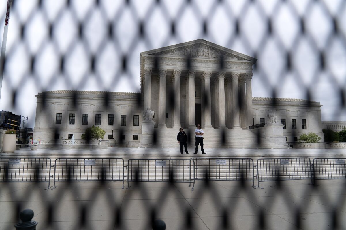 FILE - The U.S. Supreme Court is seen behind a fence who stands around the building on Thursday, May 5, 2022 in Washington. One proposal pending in Congress would provide additional security measures for the justices and another would offer more privacy and protection for all federal judges. (AP Photo/Jose Luis Magana, File)