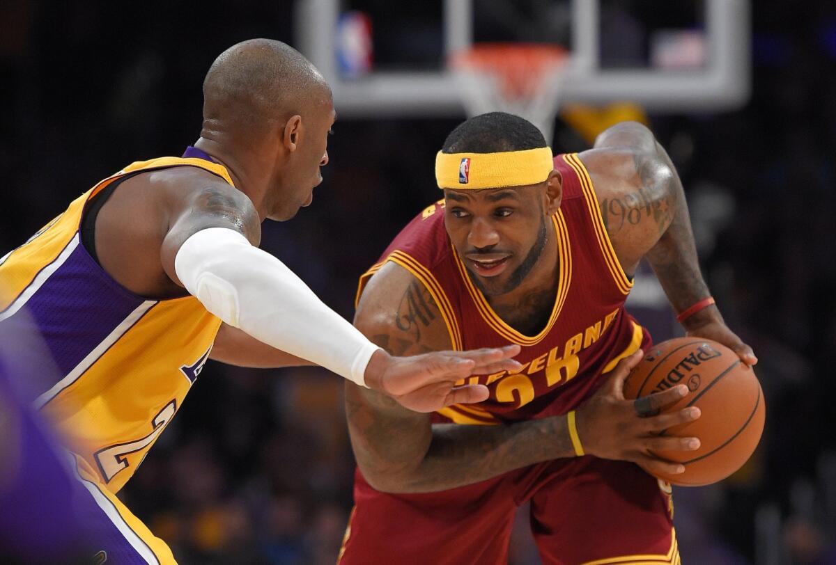 Cleveland forward LeBron James, right, tries to make a move toward the basket on Lakers guard Kobe Bryant on Thursday night at Staples Center.