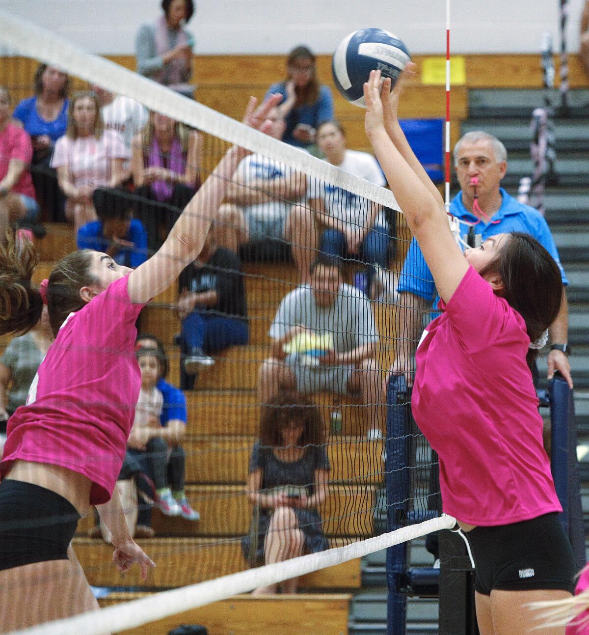 Crescenta Valley's Ellie Song and Burbank's Leah Tawil battle for a point at the top of the net in a Pacific League girls' volleyball match at Crescenta Valley High School on Thursday, October 10, 2019.in a Pacific League girls' volleyball match at Crescenta Valley High School on Thursday, October 10, 2019. Both teams wore the exact same color pink jersey in honor of Breast Cancer Awareness month.