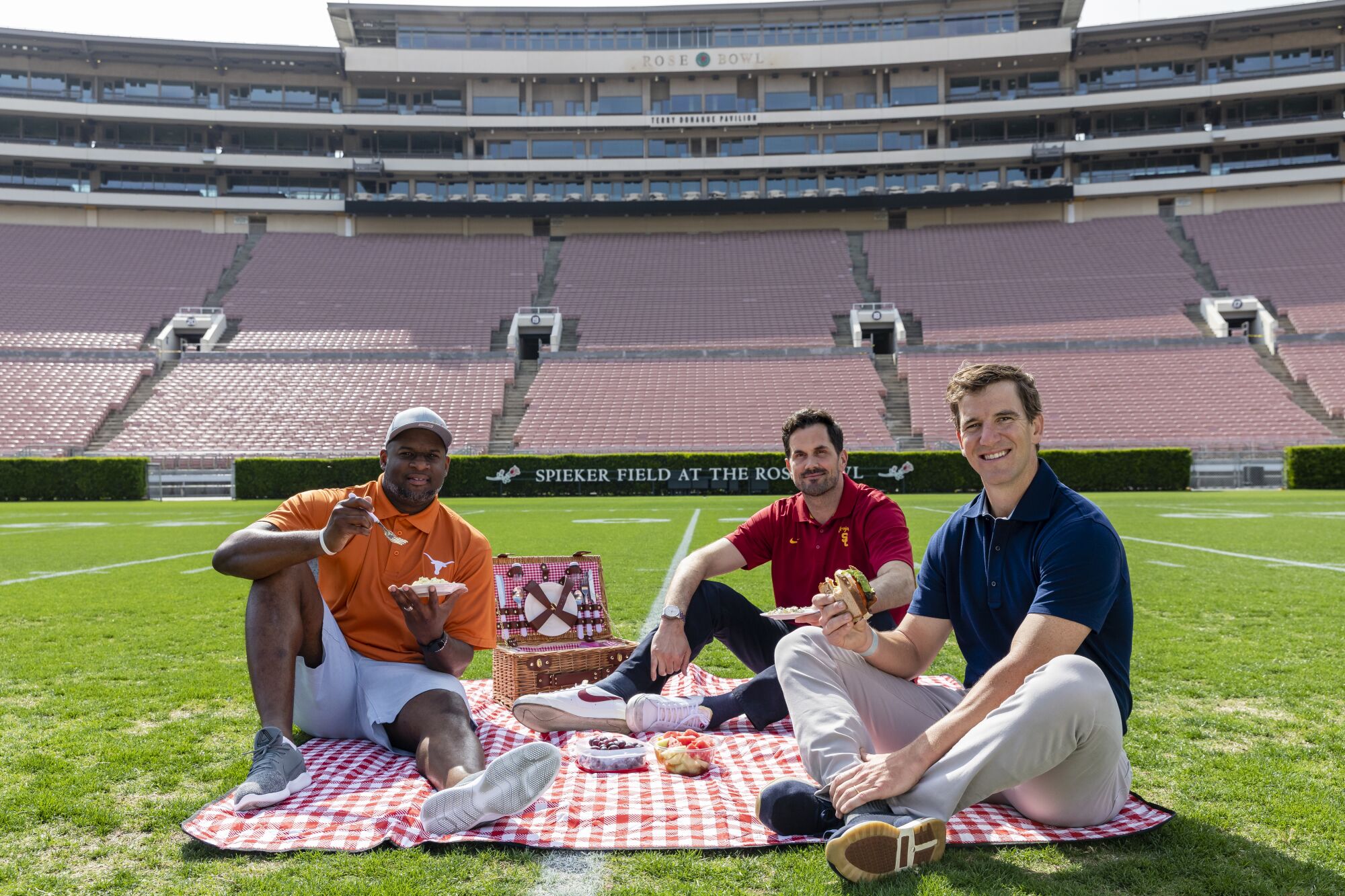 Vince Young, Matt Reinert and Eli Manning have a picnic on the Rose Bowl field.