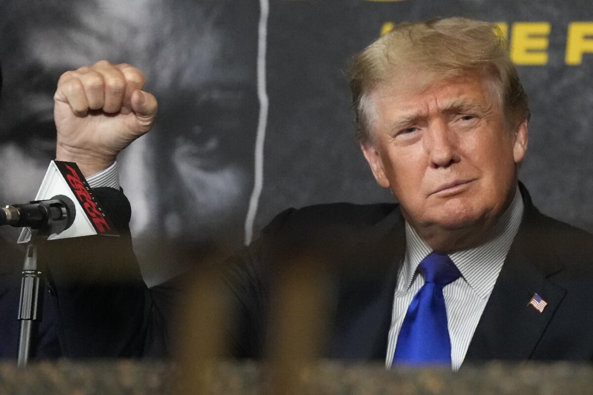 Former President Trump salutes cheering fans before a boxing match in Hollywood, Fla., on Sept. 11, 2021. 