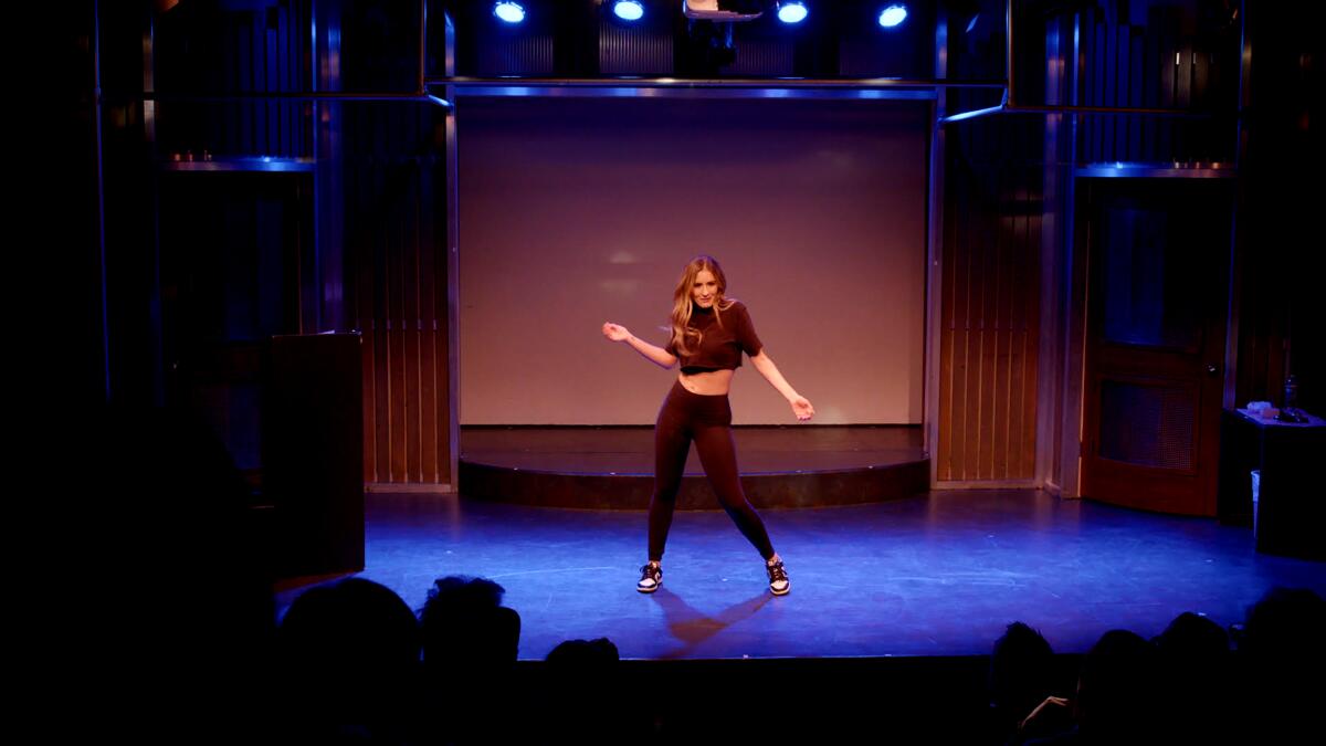 Nicole Travolta gestures onstage at her one-woman show at the Groundlings.