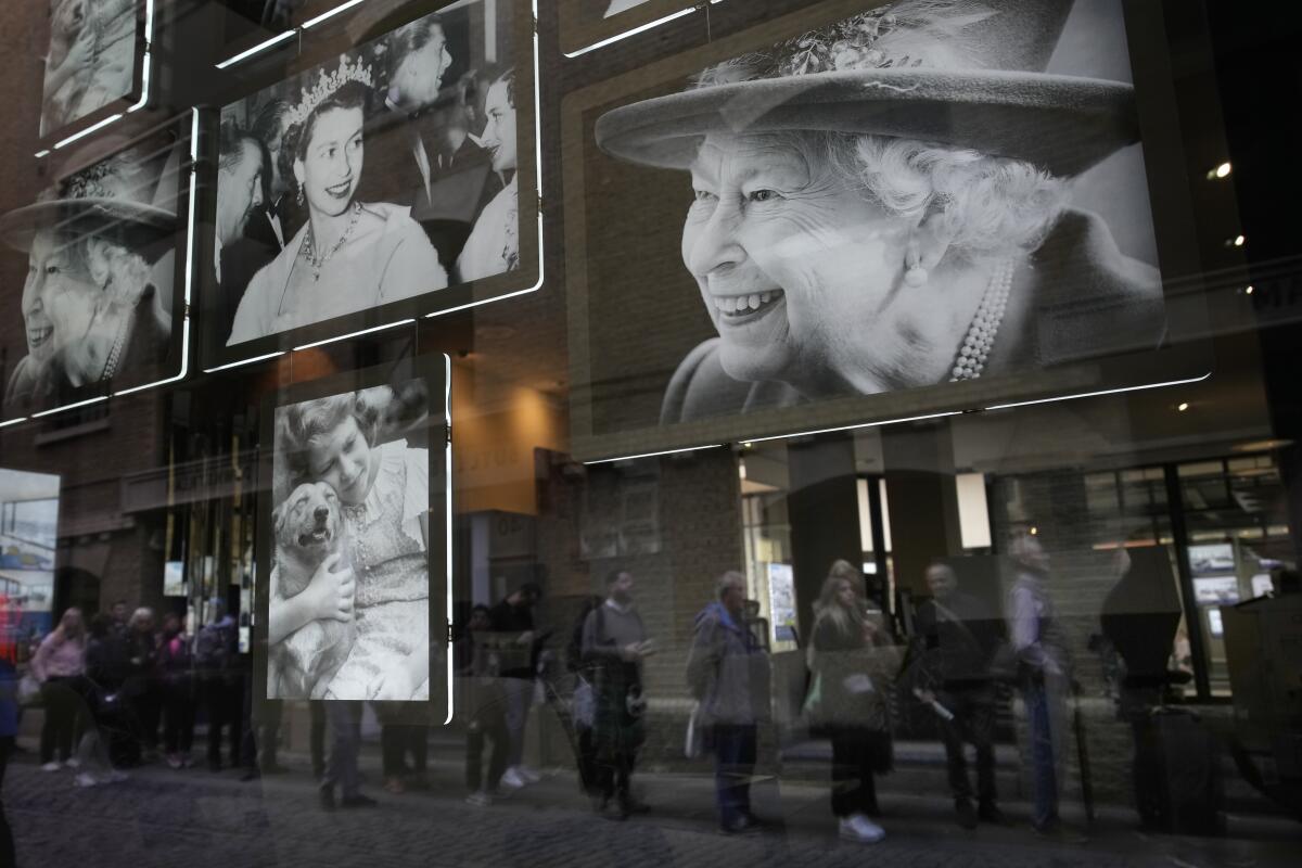 Images of Queen Elizabeth II on display as people queue to pay respects to her coffin.