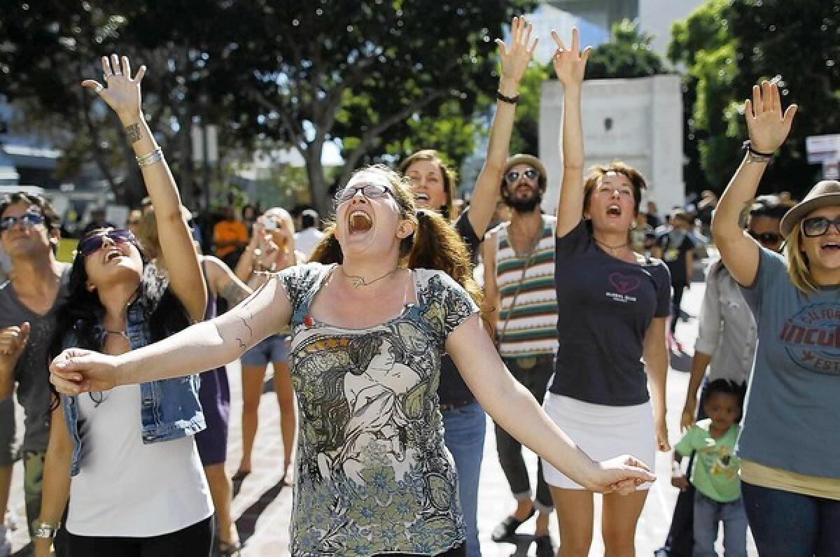 Lauren Rock of Los Angeles dances with dozens of other demonstrators as a band called the Mowglis performs on the steps of City Hall for people participating in Occupy L.A.