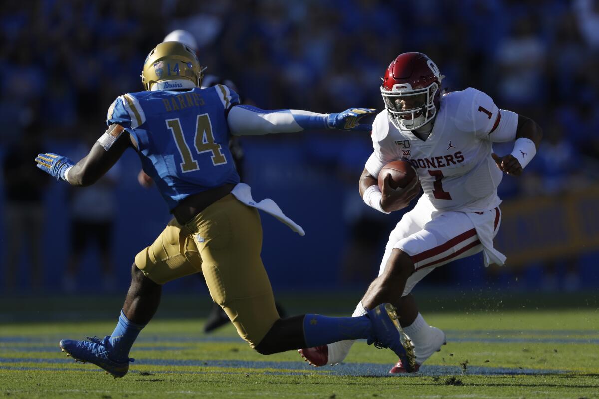 Oklahoma quarterback Jalen Hurts eludes UCLA linebacker Krys Barnes during the first half of the Bruins' 48-14 loss Saturday.