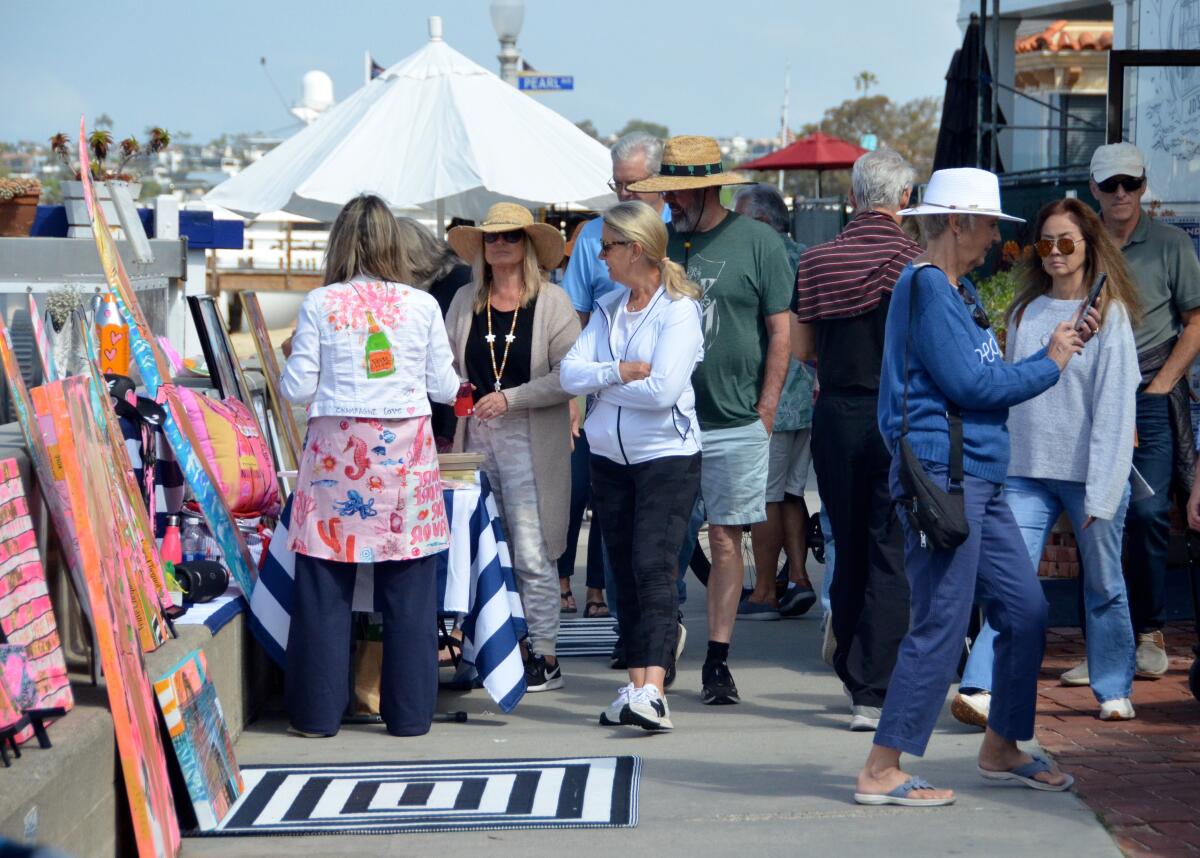 Artist Robin Hiers, left, chats with passersby during Sunday's Balboa Island Artwalk.