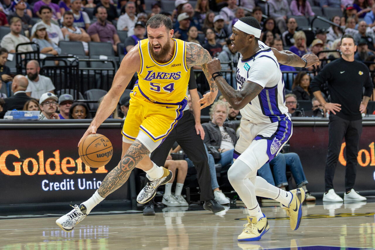 Lakers forward Sandro Mamukelashvili drives to the basket in front of Kings guard Daeqwon Plowden.