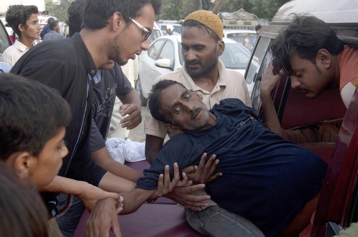 Varios hombres llevan a un hombre al hospital tras sufrir un golpe de calor en Karachi, Pakistán, el 23 de junio de 2015. (Foto AP/Shakil Adil)