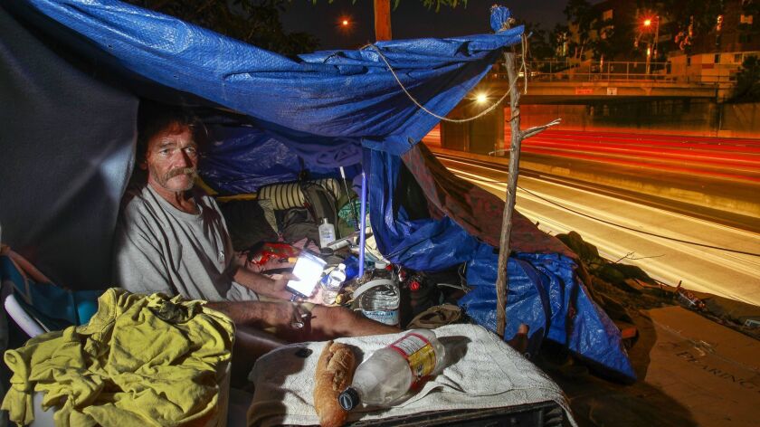 Elizah, 62, who didn't want to give his last name, sits in his makeshift tent next to the freeway in San Diego Thursday evening. He recently received a notice from Caltrans saying he has to be out by Sunday.