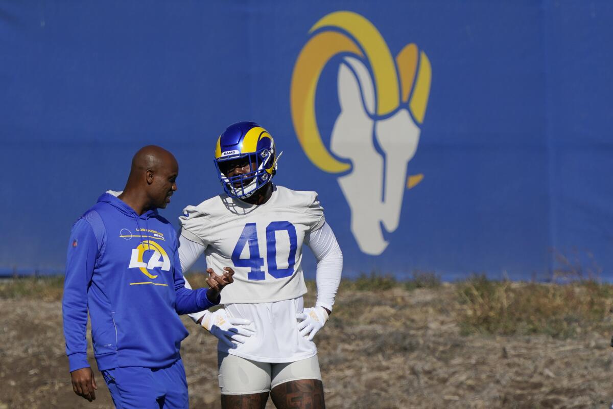 Reggie Scott, left, Rams vice president of sports medicine and performance, talks with Von Miller last season.