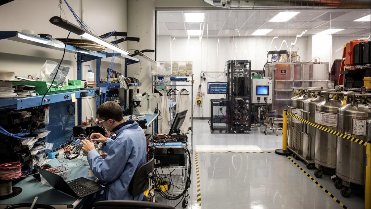 Technician Andrew Shacker works on components near the optical thermal vacuum chamber at Planet's satellite manufacturing facility in San Francisco.