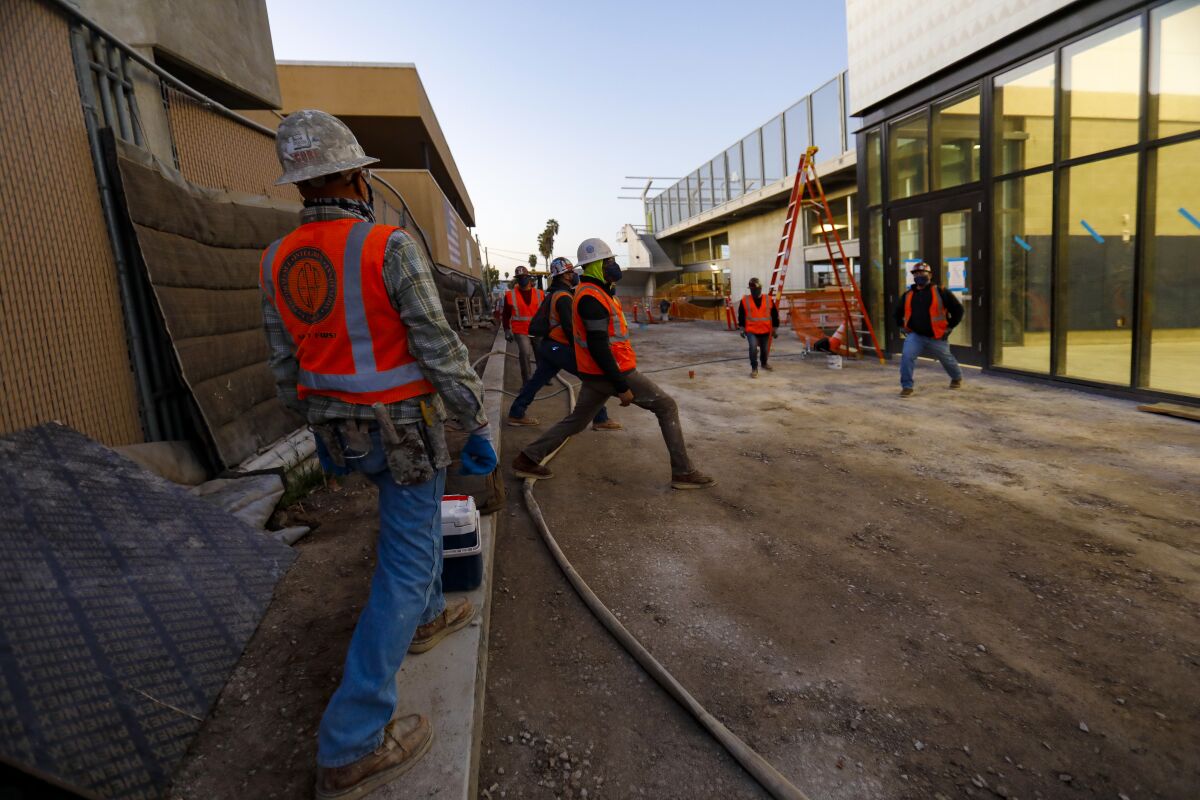 Construction workers from Brady SoCal perform stretching exercises before starting work.  