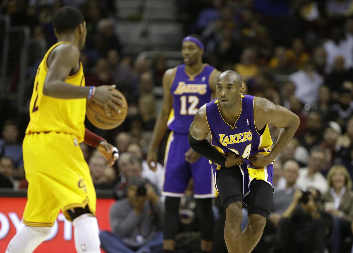 Lakers guard Kobe Bryant defends against Cleveland Cavaliers guard Kyrie Irving on Dec. 11, 2012.